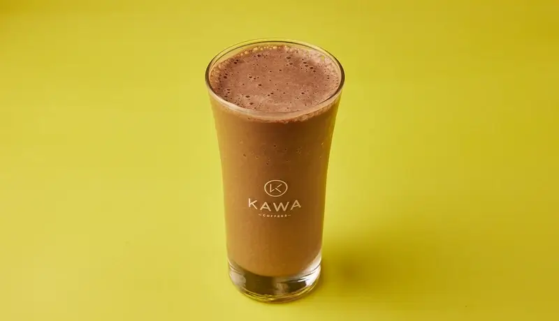 Ποτήρι με κρύα σοκολάτα πάνω σε κίτρινο φόντο